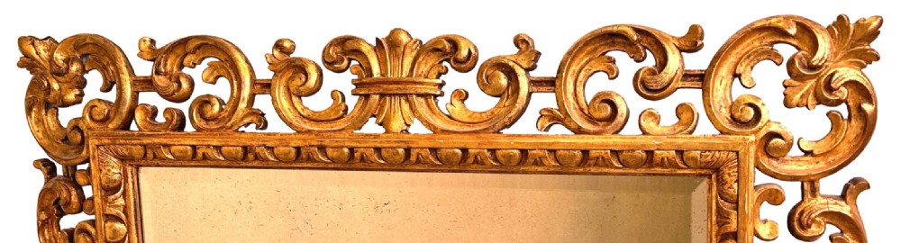 A late 18th-century Italian rectangular wall mirror featuring an intricate carved openwork giltwood frame with scroll motifs and acanthus leaf details. View IV