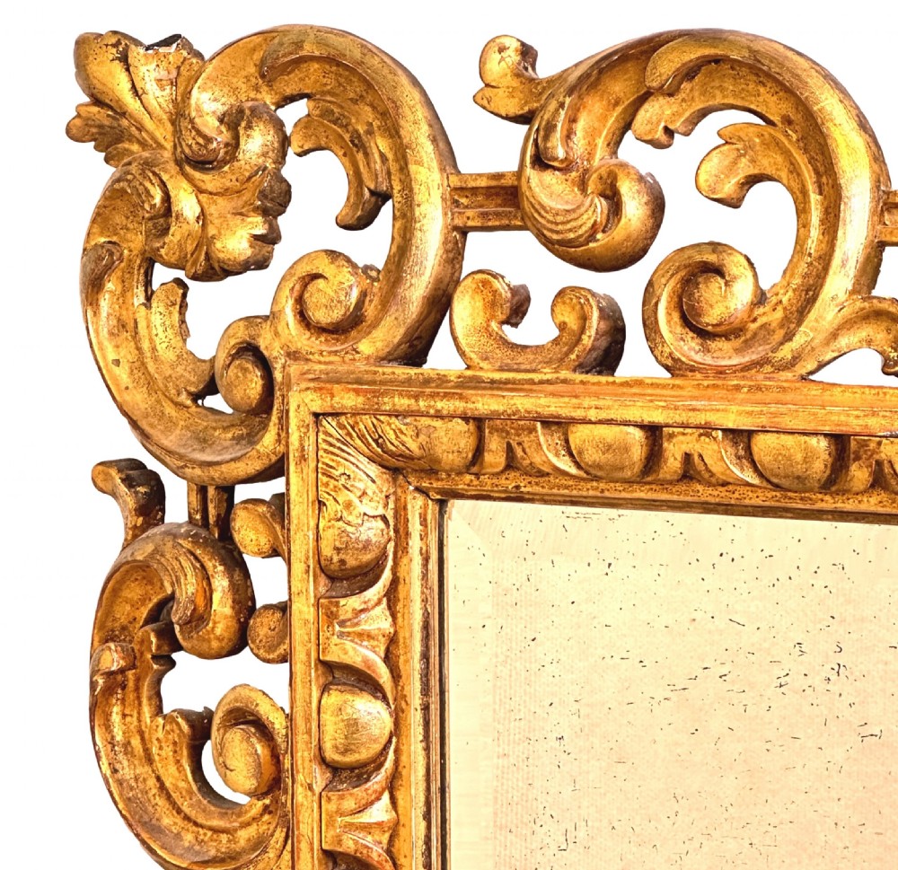 A late 18th-century Italian rectangular wall mirror featuring an intricate carved openwork giltwood frame with scroll motifs and acanthus leaf details. View V