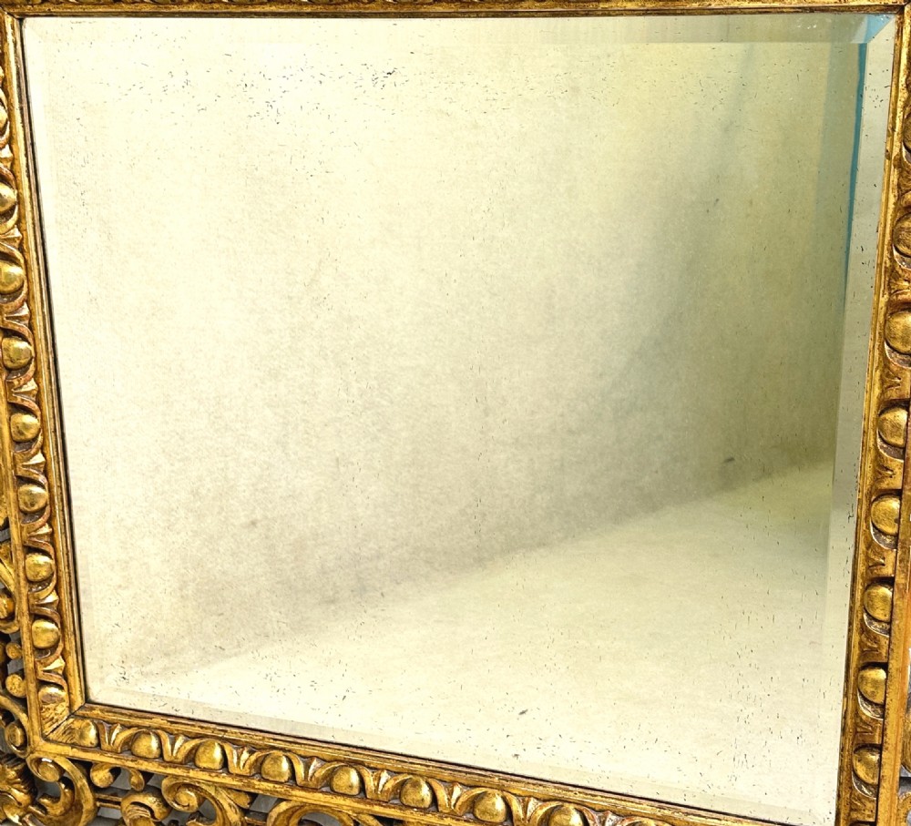 A late 18th-century Italian rectangular wall mirror featuring an intricate carved openwork giltwood frame with scroll motifs and acanthus leaf details. View VII