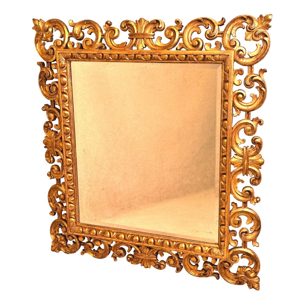 A late 18th-century Italian rectangular wall mirror featuring an intricate carved openwork giltwood frame with scroll motifs and acanthus leaf details. View IX