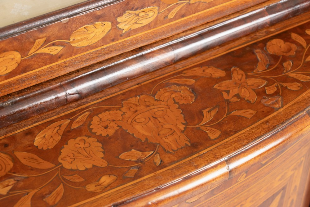 An antique two-tier Dutch corner cupboard featuring detailed floral marquetry inlay, an arched glazed upper door, and a solid lower cupboard door. View VIII
