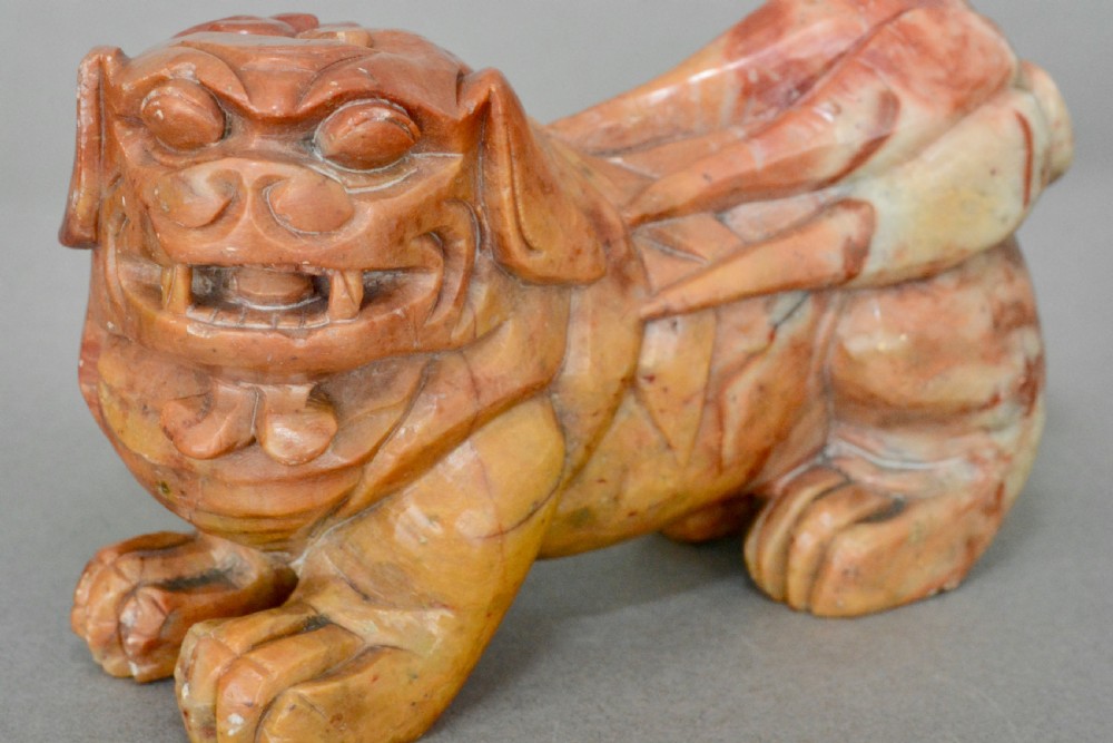 A hand-carved soapstone sculpture depicting a Chinese guardian foo dog in tones of terracotta brown, ochre, and cream. View II