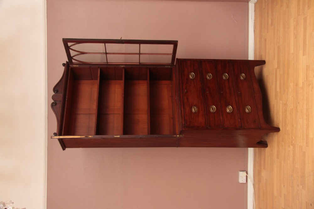 An antique dark mahogany bureau bookcase featuring a shaped pediment, twin astragal glazed doors, and four lower drawers with oval brass handles. View IX
