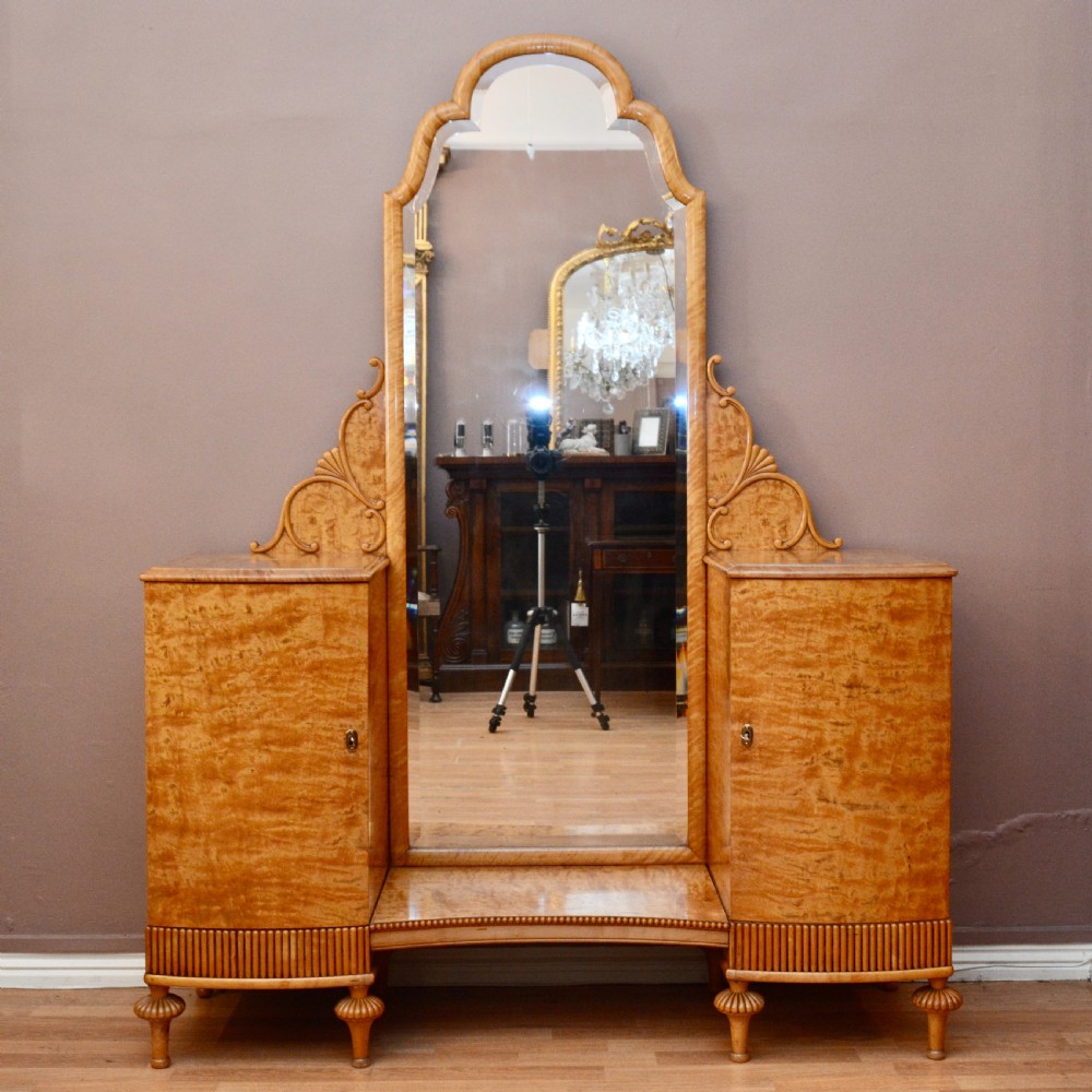 A Swedish satin birch dressing table featuring a tall central arched mirror flanked by two side pedestals with carved scroll brackets and reeded feet. View II