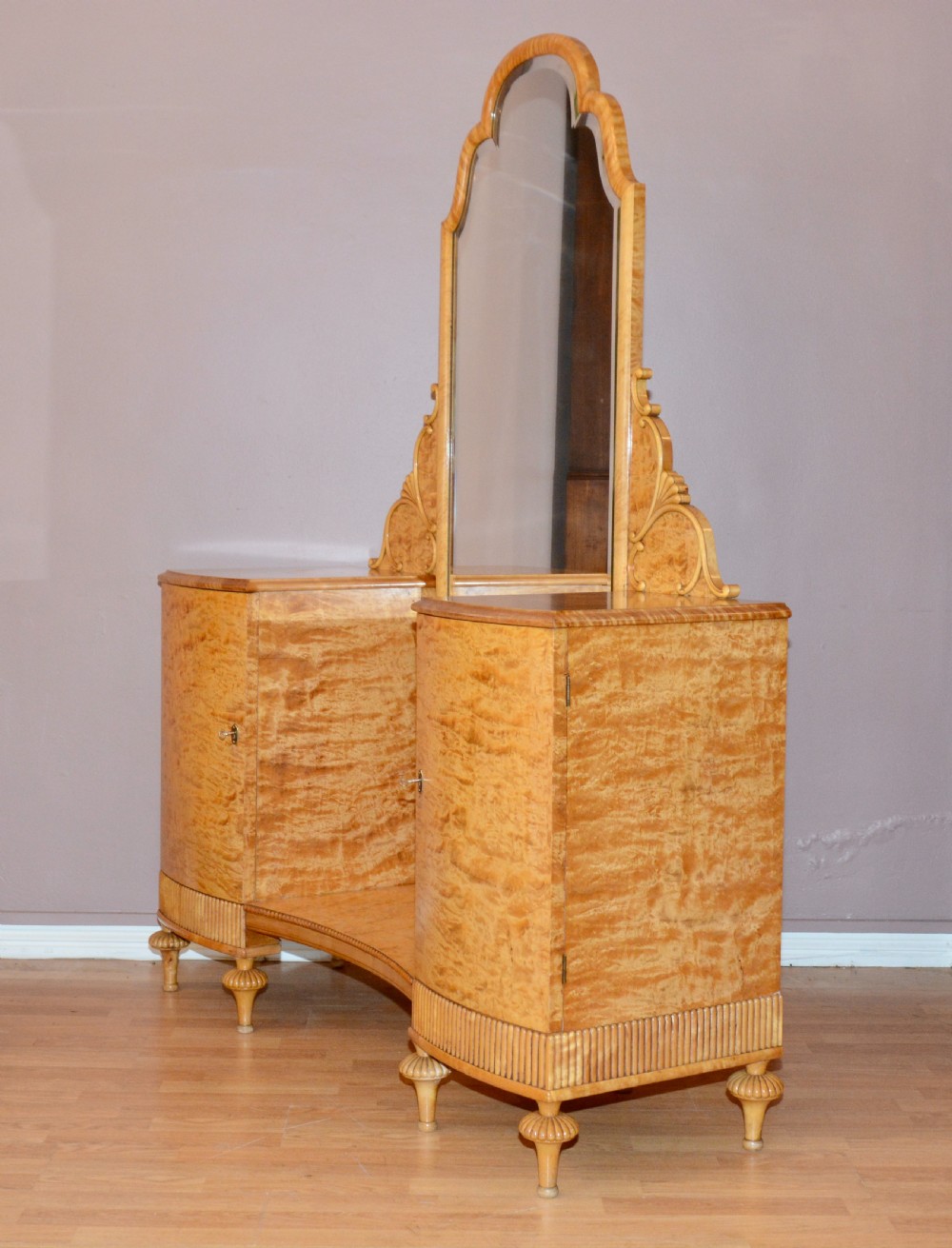 A Swedish satin birch dressing table featuring a tall central arched mirror flanked by two side pedestals with carved scroll brackets and reeded feet. View III