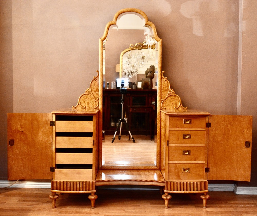A Swedish satin birch dressing table featuring a tall central arched mirror flanked by two side pedestals with carved scroll brackets and reeded feet. View IV