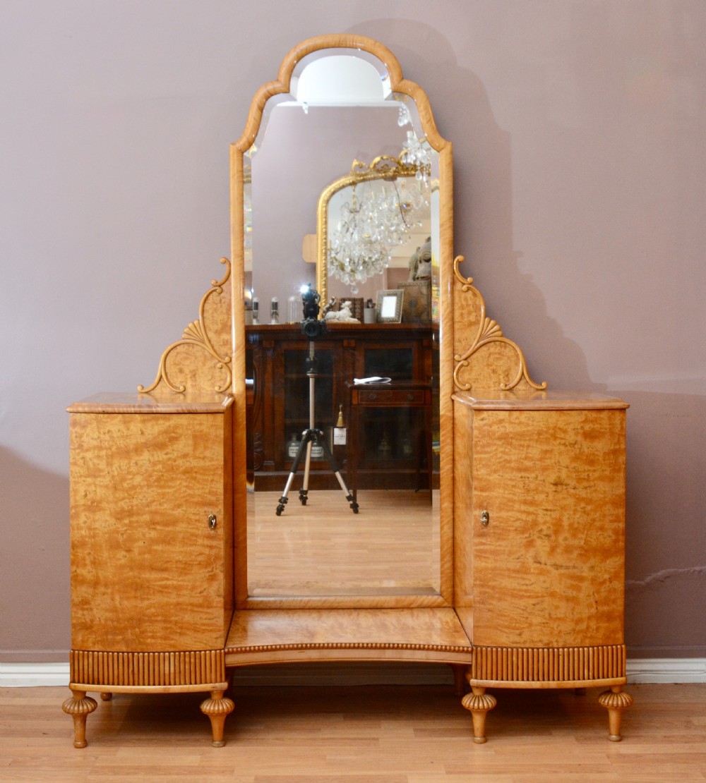 A Swedish satin birch dressing table featuring a tall central arched mirror flanked by two side pedestals with carved scroll brackets and reeded feet. View V
