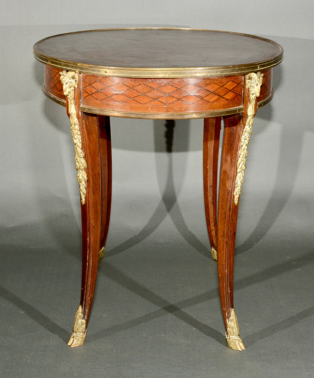 A 19th-century French Louis XV style oval centre table featuring sunburst and diaper marquetry, polished gilt bronze rim and mounts, resting on curved legs ending in hoof feet. View III