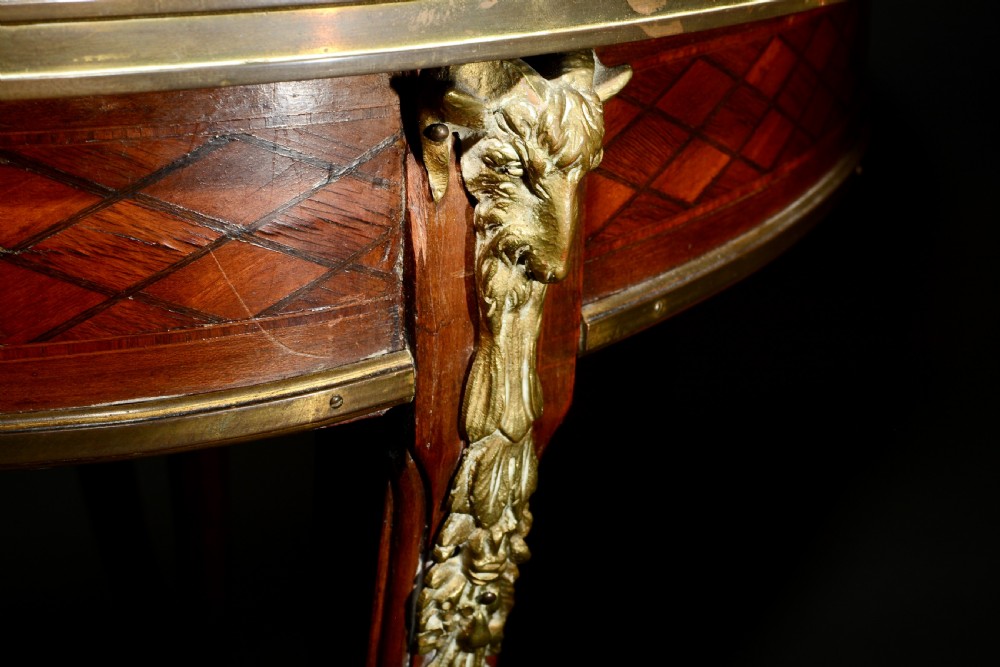 A 19th-century French Louis XV style oval centre table featuring sunburst and diaper marquetry, polished gilt bronze rim and mounts, resting on curved legs ending in hoof feet. View V