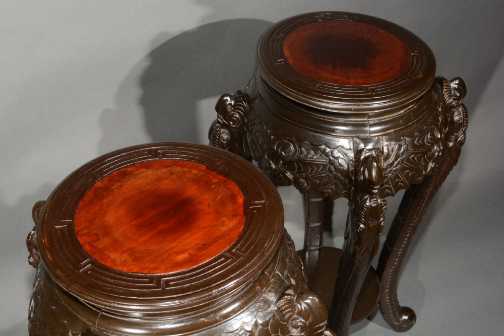 A pair of dark wood carved Asian plant stands featuring round inset tops, openwork aprons, cabriole legs, and lower circular shelves. View III