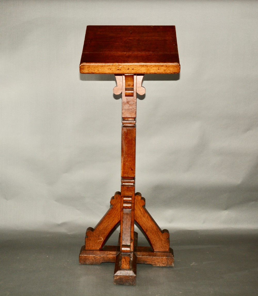 A Victorian carved oak church lectern featuring an angled reading ledge supported by a central column and a four-point braced base.