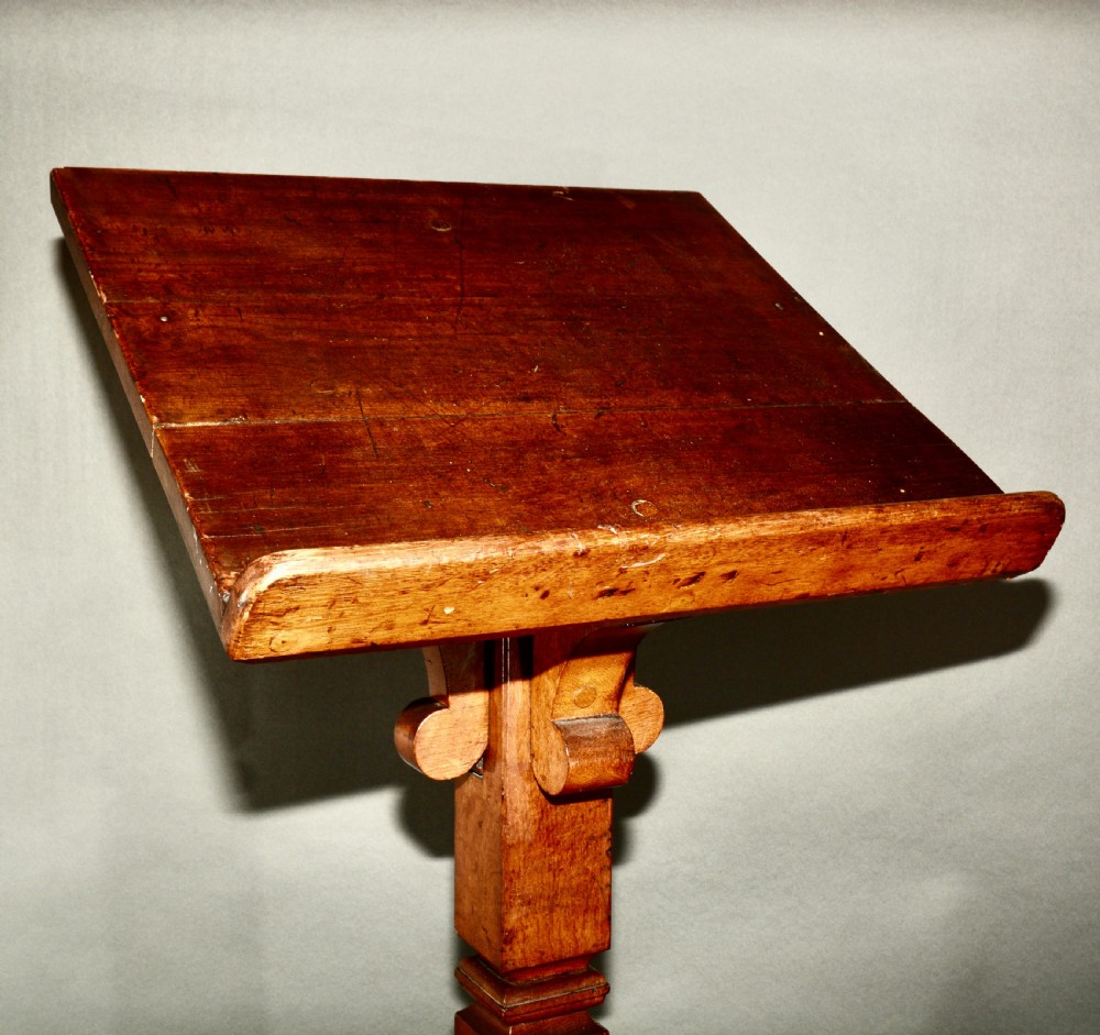 A Victorian carved oak church lectern featuring an angled reading ledge supported by a central column and a four-point braced base. View VI