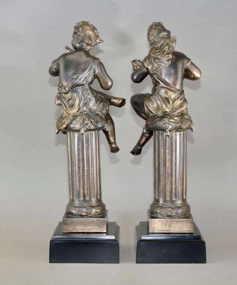 A pair of mid-19th-century bronze sculptures featuring cherubs playing musical instruments while seated atop fluted columns. View III