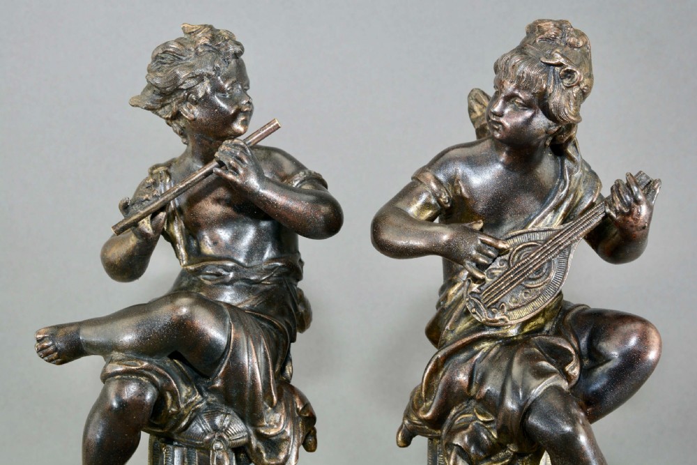 A pair of mid-19th-century bronze sculptures featuring cherubs playing musical instruments while seated atop fluted columns. View IV
