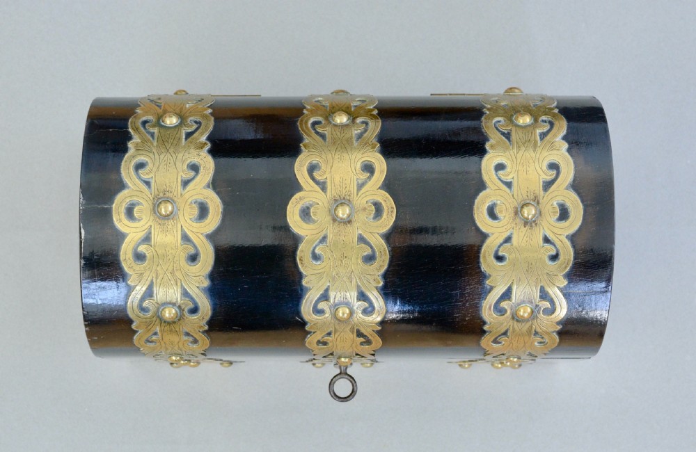 A dark coromandel wood domed stationery box decorated with intricate engraved brass straps and central keyhole. View III