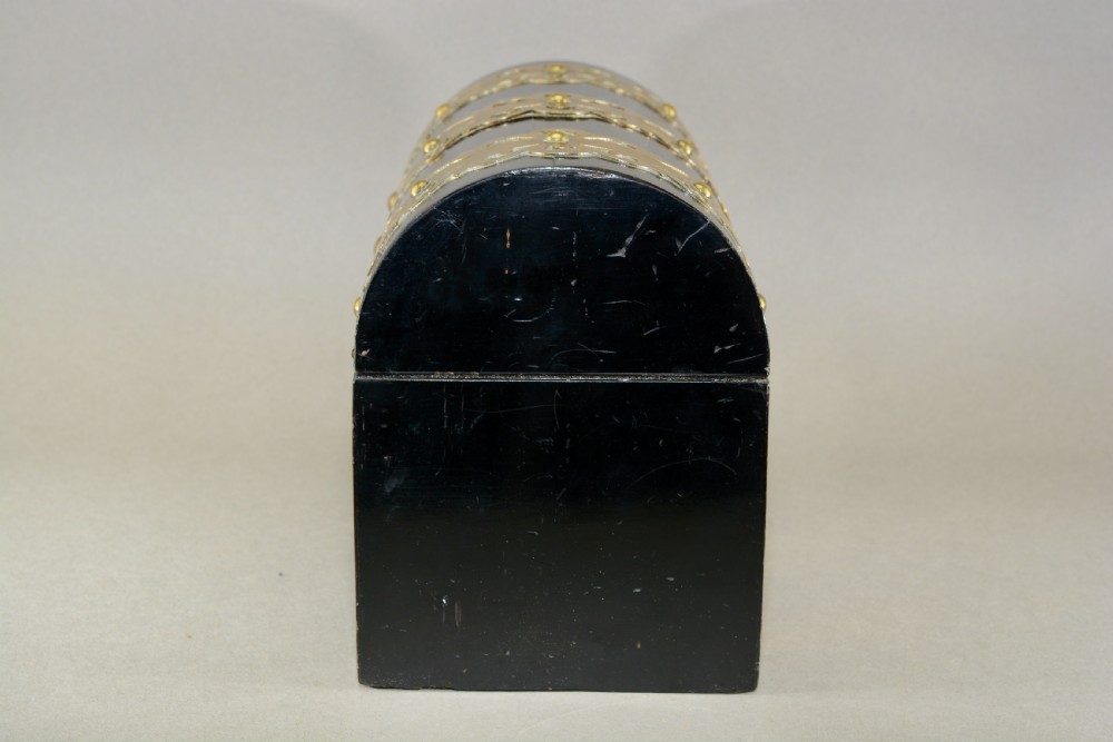 A dark coromandel wood domed stationery box decorated with intricate engraved brass straps and central keyhole. View VII
