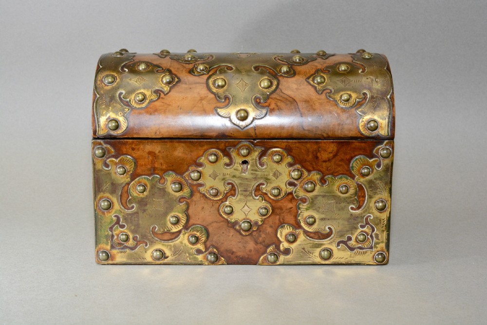 A Victorian dome-topped figured walnut stationery box featuring ornate pierced brass mounts and studs.