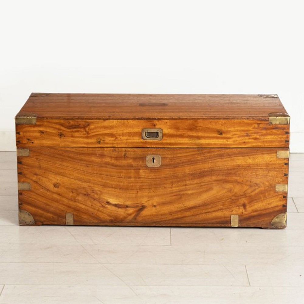 A rectangular mid-nineteenth century camphorwood campaign chest with flush brass corner brackets, central keyhole, and side handles.