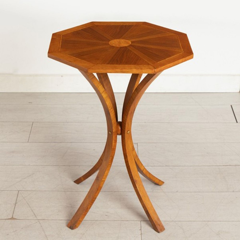 An Art Deco octagonal wooden occasional table featuring a starburst veneer top and four sweeping curved legs connected at the centre.