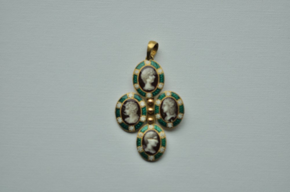 An antique 22ct gold pendant featuring four oval green enamelled medallions with profile portrait miniatures arranged in a cross formation.