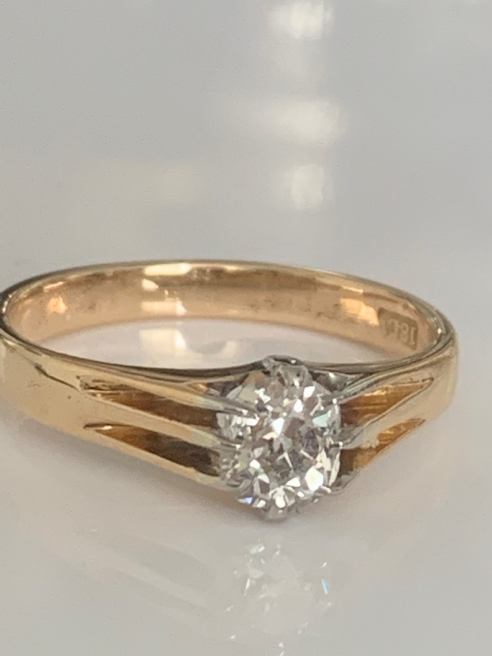 An Edwardian yellow gold solitaire ring featuring a single old mine cut diamond held in a multi-claw setting. View IV
