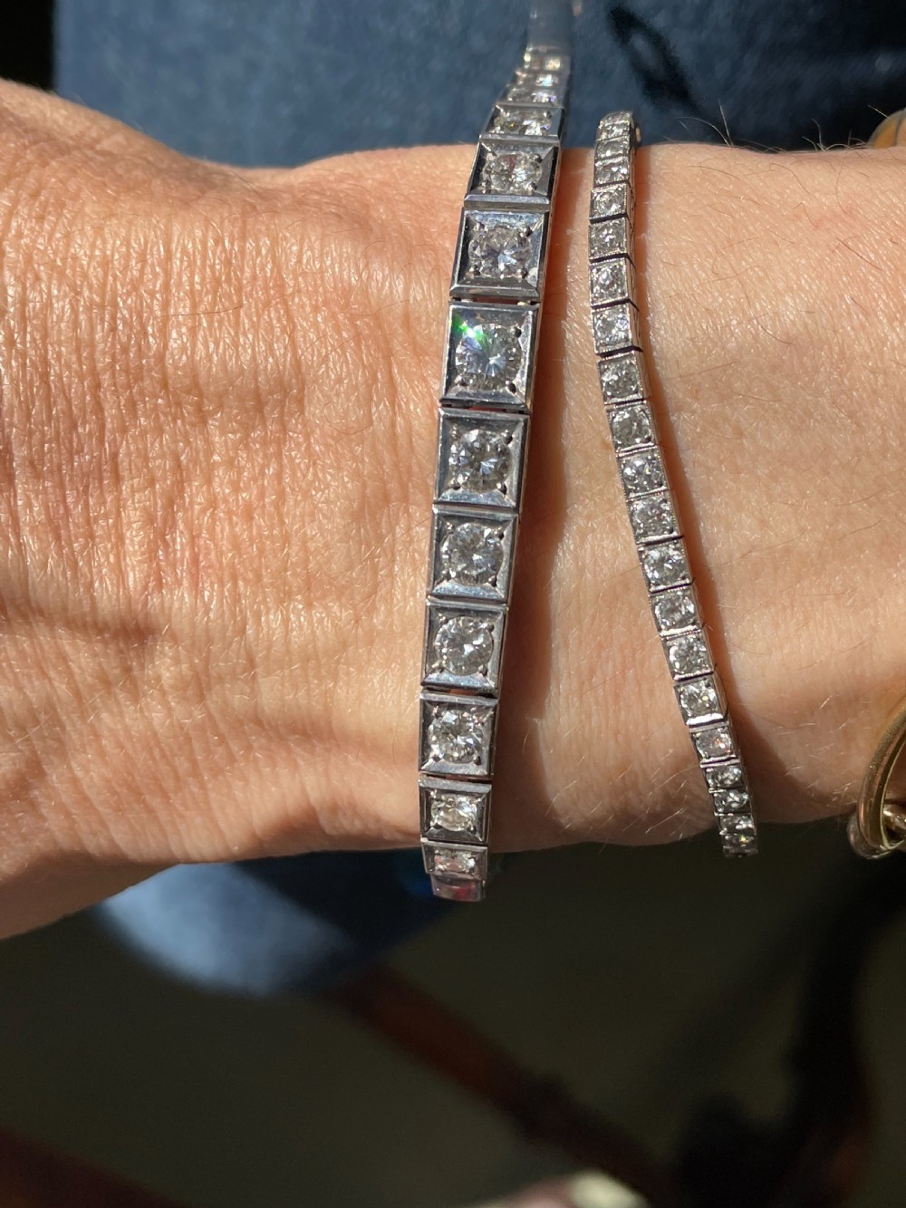 A mid-twentieth-century white gold line bracelet featuring round diamonds set within square box links with hand-engraved side details. View II