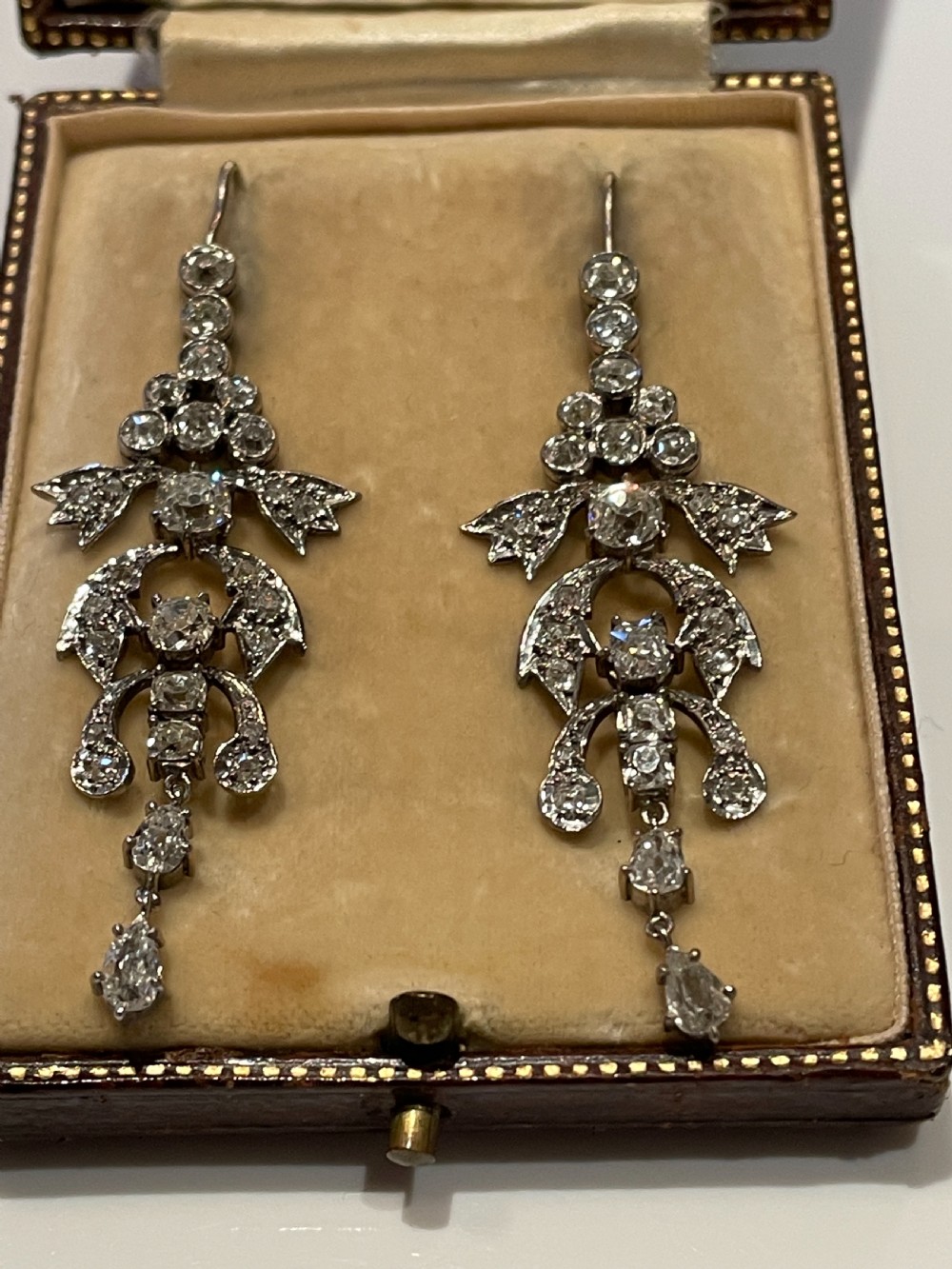 Pair of early 20th-century articulated drop earrings set with old European cut diamonds in an intricate garland framework.