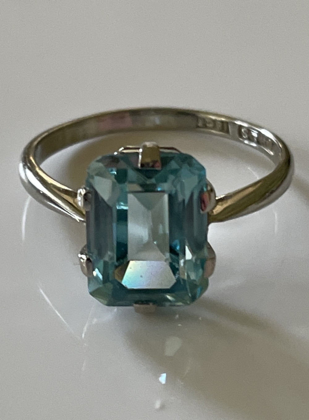 A mid-century white gold ring featuring a rectangular emerald-cut light blue zircon gemstone held in a claw setting. View II