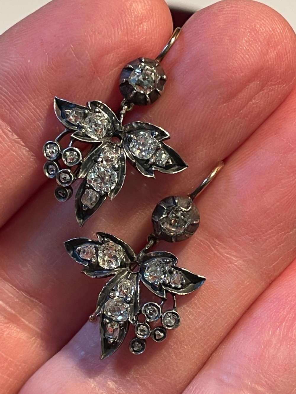 A pair of Victorian drop earrings featuring foliate leaf motifs set with old-cut diamonds in patinated silver.