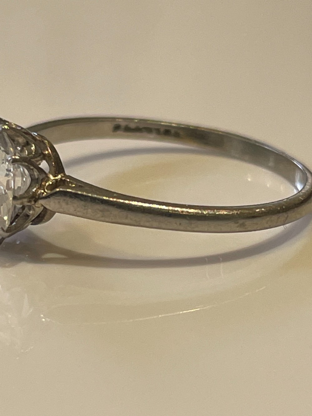 An antique diamond solitaire ring featuring a round old-cut diamond set in an eight-claw white metal mount. View II