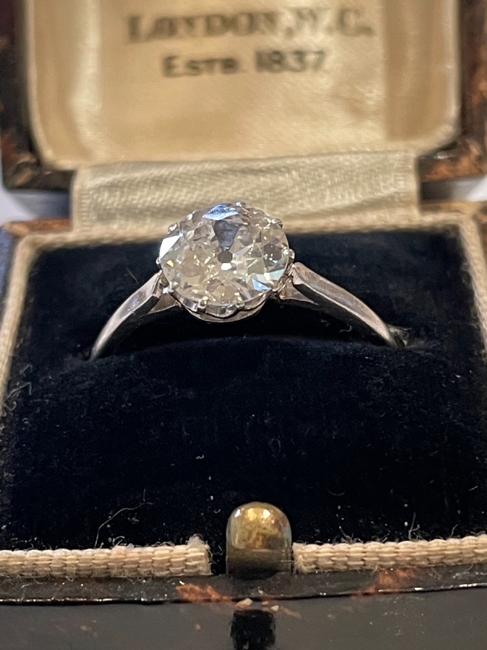 An antique diamond solitaire ring featuring a round old-cut diamond set in an eight-claw white metal mount. View IV
