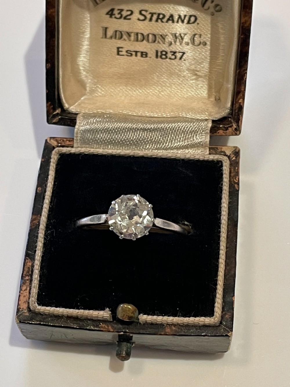 An antique diamond solitaire ring featuring a round old-cut diamond set in an eight-claw white metal mount. View VI