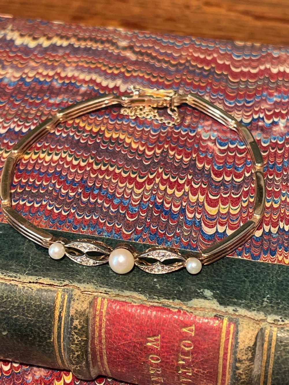 An Edwardian gold and platinum link bracelet featuring central pearls flanked by openwork diamond-set filigree motifs. View II
