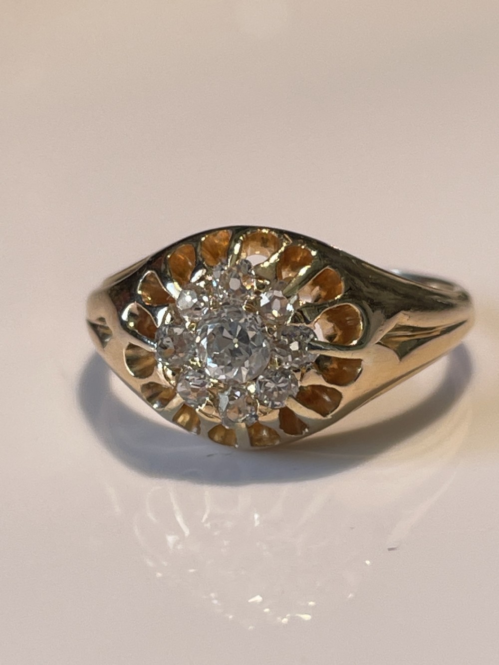 A Victorian yellow gold ring featuring a central cluster of old cut diamonds with carved detail along the shoulders. View IV
