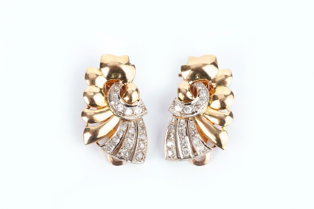 A pair of Art Deco 18ct yellow gold and diamond clip earrings featuring a ribbed fan motif with diamond-set accents.