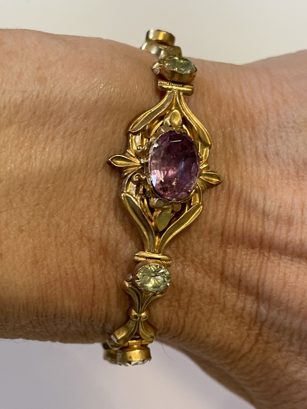 A Victorian gold link bracelet set with alternating oval chrysoberyl and amethyst gemstones, displayed inside an open fitted leather presentation box. View IV