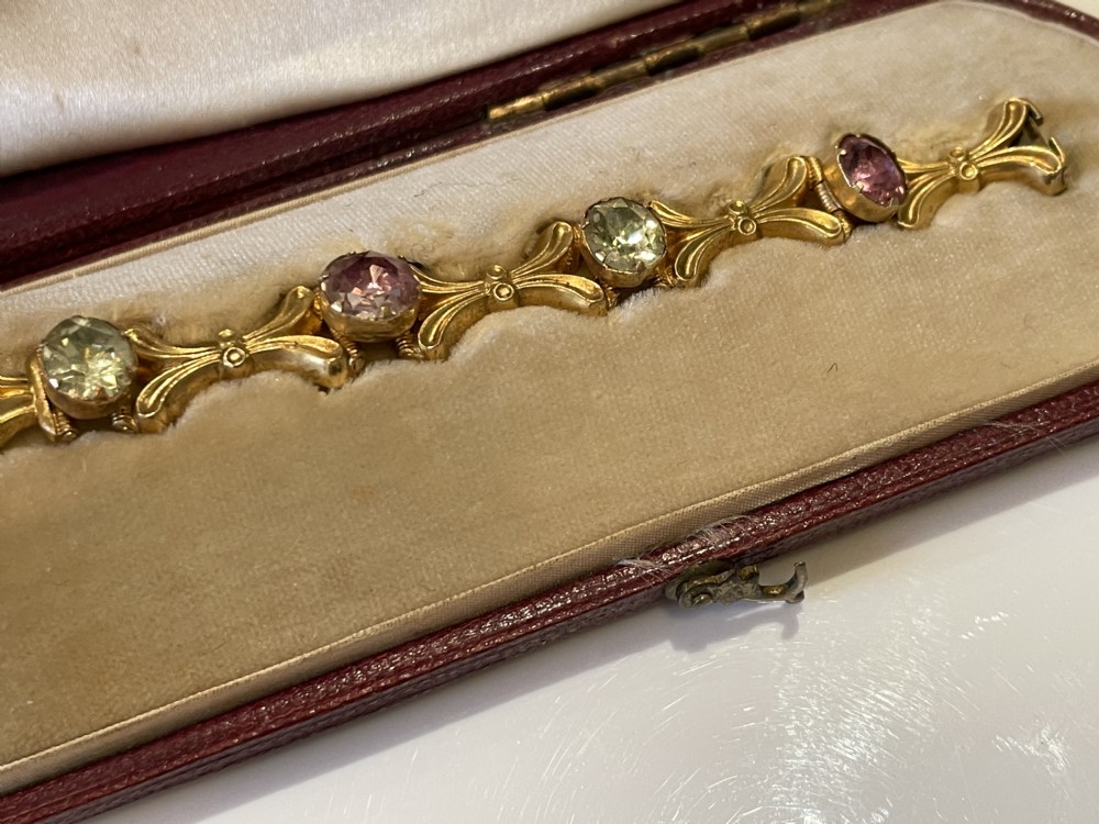 A Victorian gold link bracelet set with alternating oval chrysoberyl and amethyst gemstones, displayed inside an open fitted leather presentation box. View IX