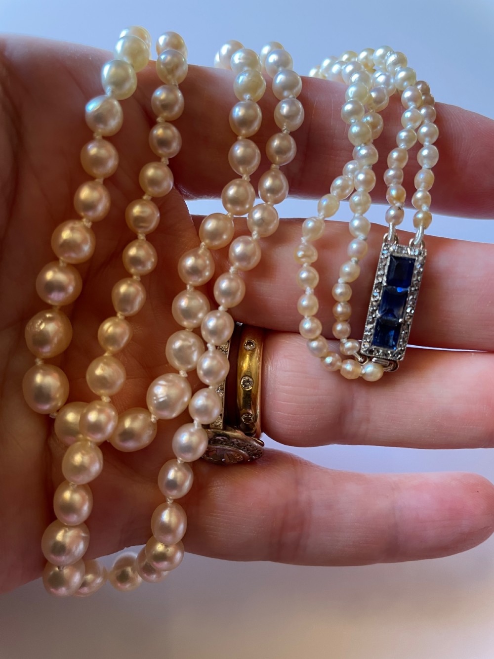 A double-strand cream pearl necklace displayed on a neck, featuring lustrous spherical pearls. View II