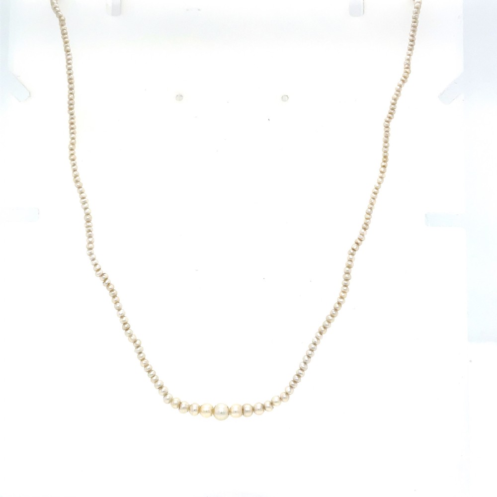 A single strand of natural saltwater pearls fitted with a geometric pierced metal clasp. View IV