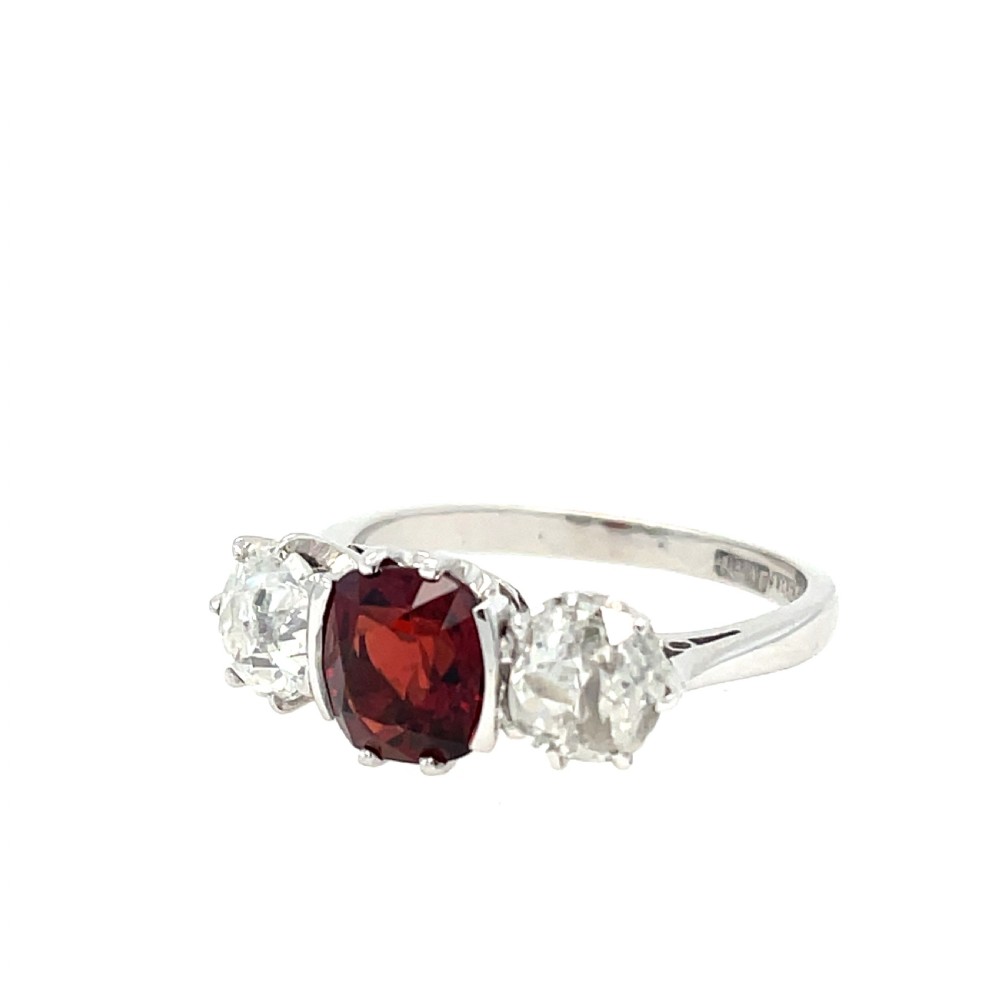 An antique platinum three-stone ring featuring a central cushion-cut red spinel flanked by two old cut diamonds. View II