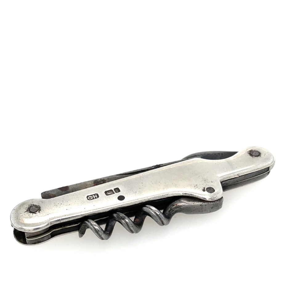 An antique sterling silver folding pocket corkscrew featuring visible hallmarks on its casing.