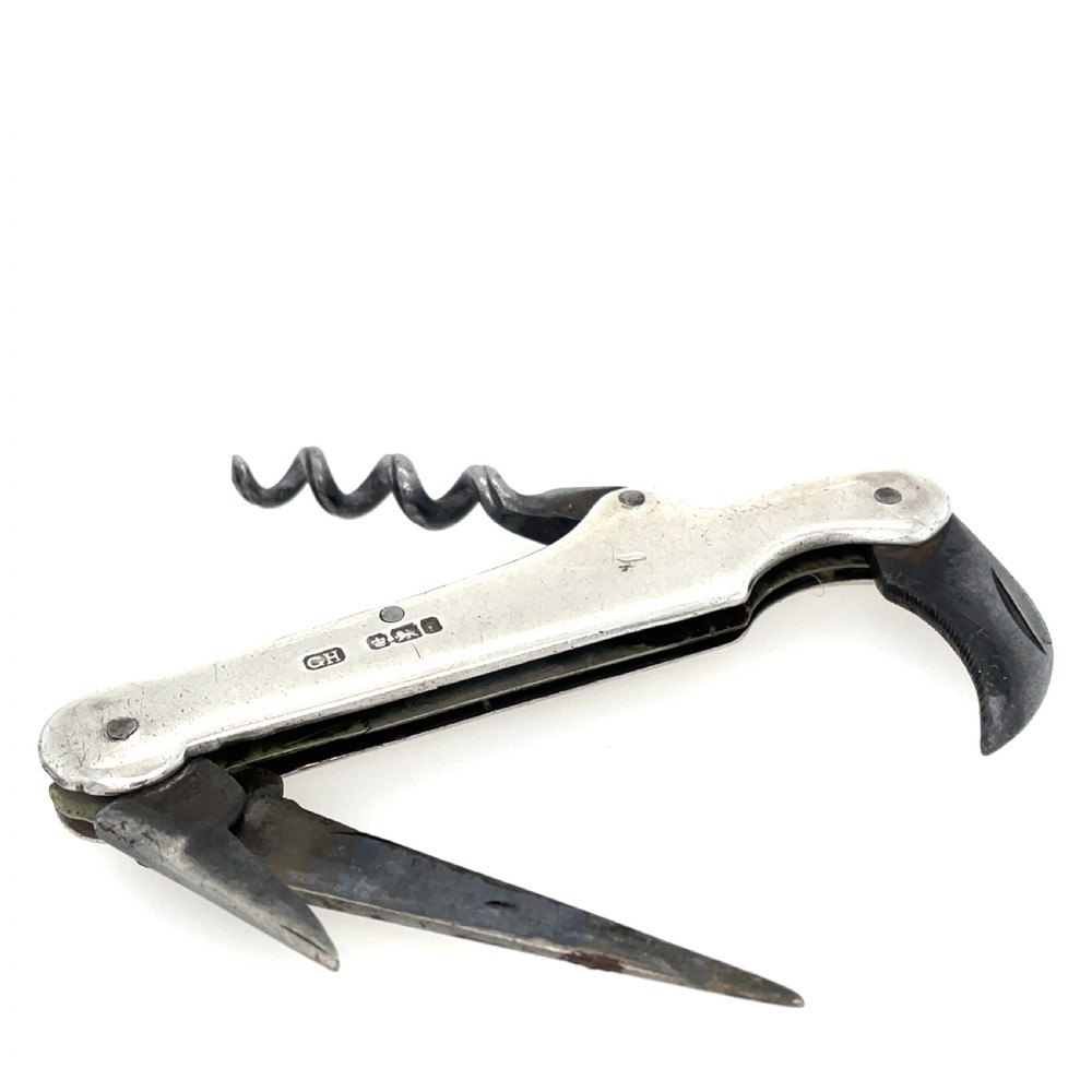 An antique sterling silver folding pocket corkscrew featuring visible hallmarks on its casing. View II