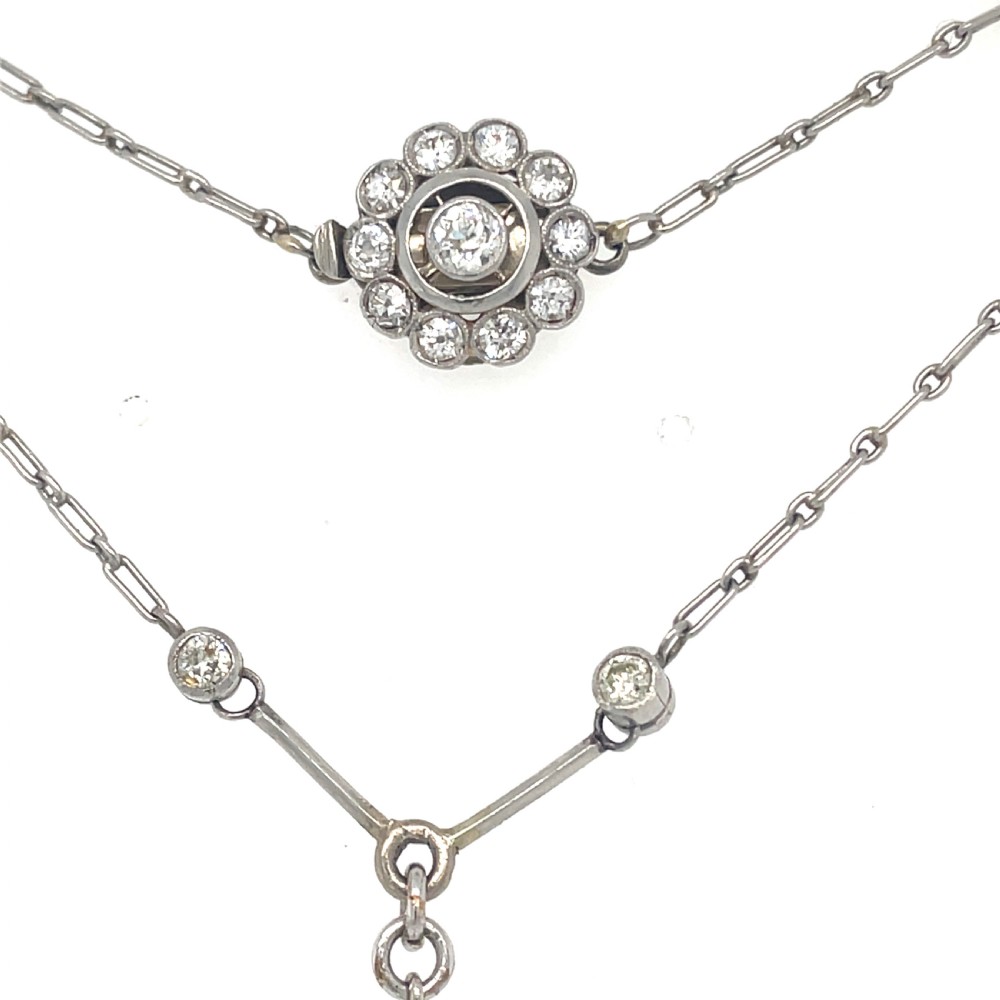 An Edwardian platinum pendant featuring an oval cushion-cut yellow sapphire suspended from a diamond-set drop chain. View V