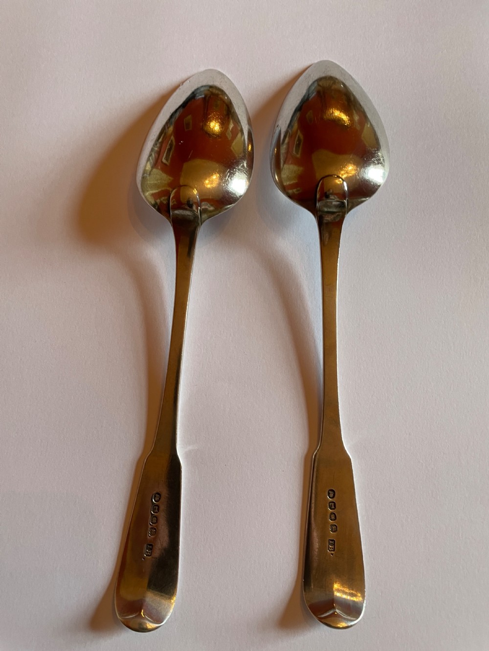 A pair of Georgian sterling silver serving spoons with smooth oval bowls and engraved monograms on the handles. View II