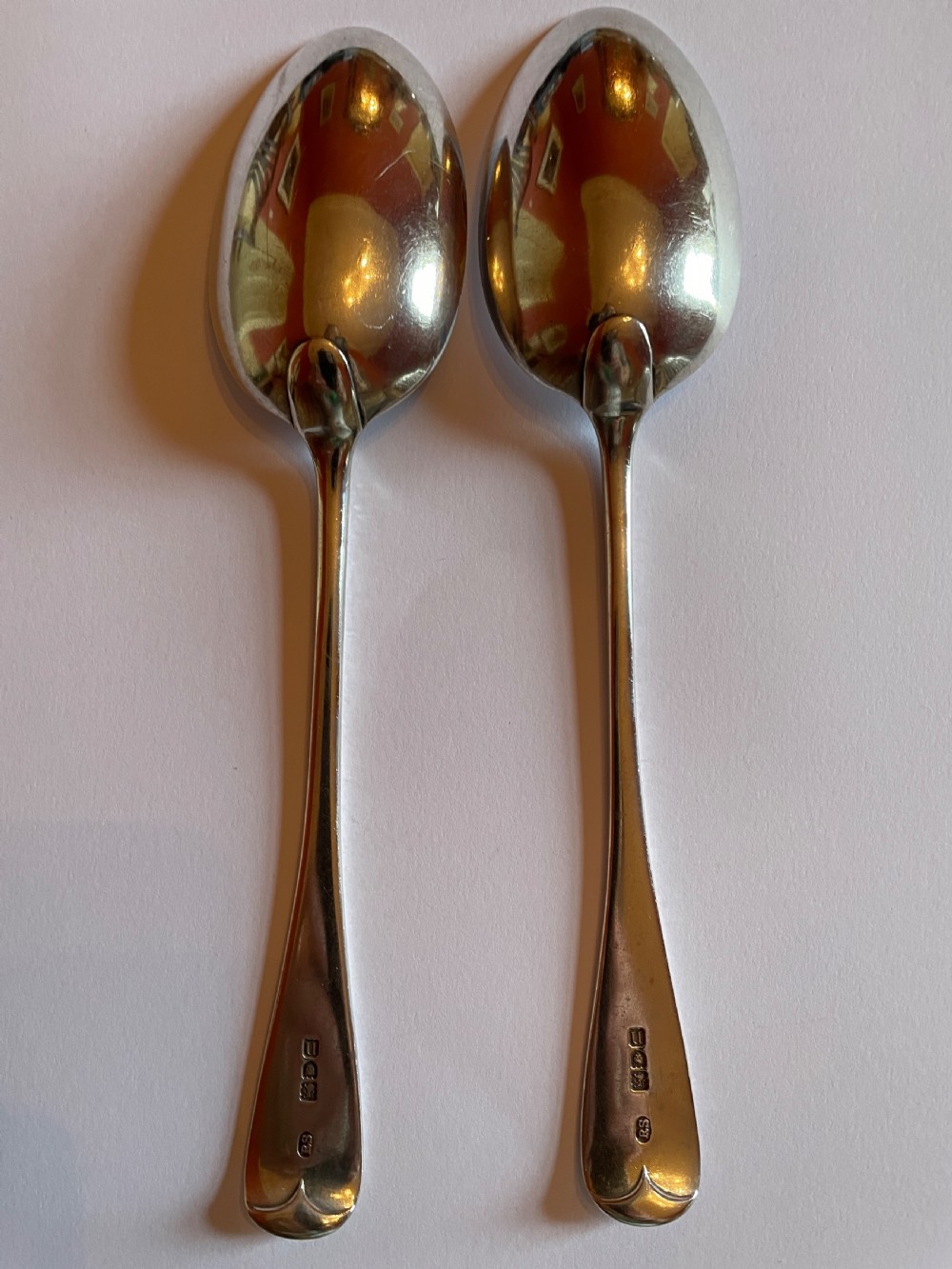 A pair of polished Georgian sterling silver serving spoons featuring elongated oval bowls and smooth tapered handles. View II