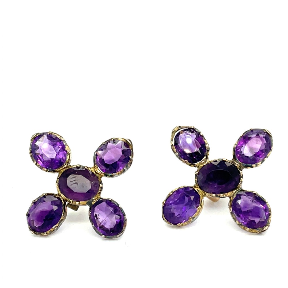A pair of Georgian earrings featuring five oval, flat-cut purple amethysts set in a cross arrangement within crimped metal collets.