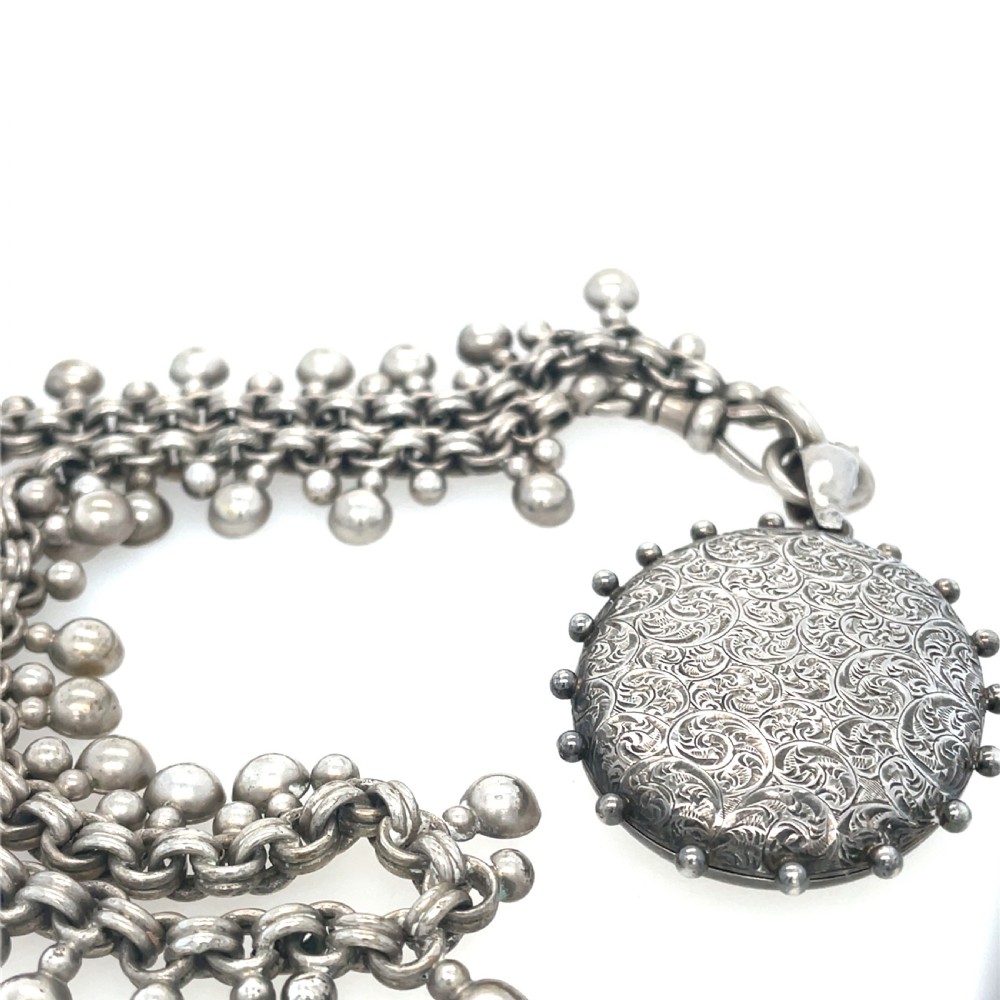 A round Edwardian gold locket engraved with a swallow in flight and floral foliage on a fine chain. View II