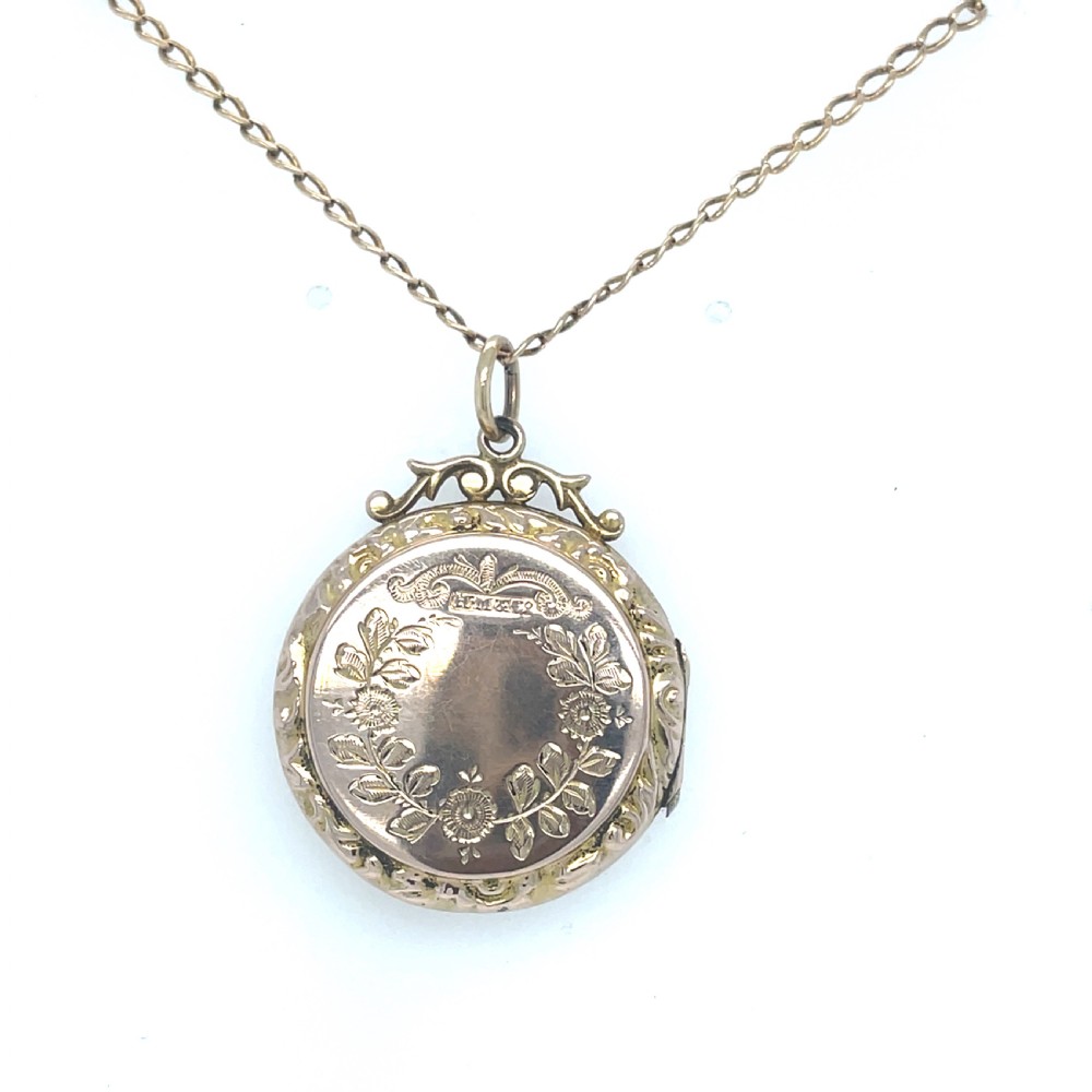 A round Edwardian gold locket engraved with a swallow in flight and floral foliage on a fine chain. View III