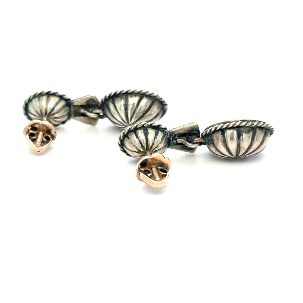 A pair of late 19th-century silver drop earrings set with two oval-cut pale blue aquamarines enclosed in rope-twist borders. View II