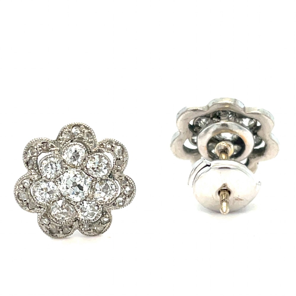 A pair of floral-shaped stud earrings set with central old European cut diamonds surrounded by millegrain-bordered diamond petals. View II